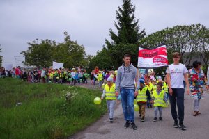 Uczestnicy przemarszu z transparentami i plakatami z hasłami kampanii