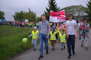 Uczestnicy przemarszu niosący transparenty