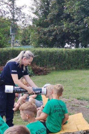 policjantka opowiadająca dzieciom o ważnej roli odblasków na drodze