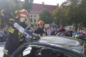 Strażak rozcinający dach w samochodzie osobowym.