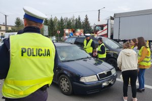 Policjanci i uczniowie rozmawiający z kierowcą zatrzymanym w ramach działań EDWARD