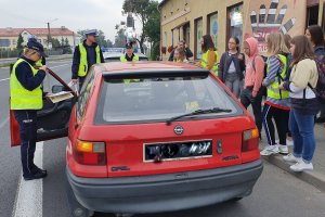 policjantka rozmawia z kierowcą i wręcza mu dyplom za rozważną jazdę