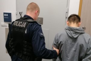 policjant prowadzący zatrzymanego mężczyznę