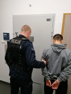 policjant prowadzący zatrzymanego mężczyznę