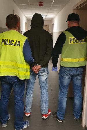 policjanci prowadzą sprawcę kradzieży