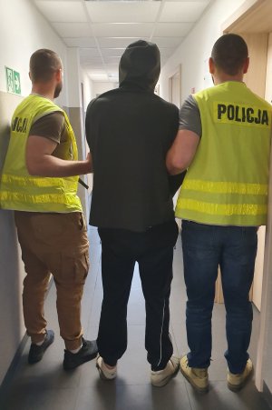 policjanci prowadzą zatrzymanego