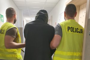 policjanci prowadzą zatrzymanego