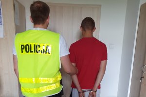 policjant trzymający zatrzymanego mężczyznę