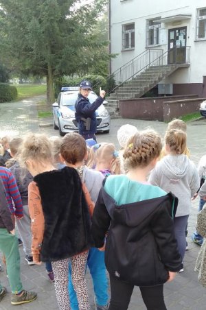 policjantka stoi przed grupą przedszkolaków i mówi o bezpiecznych i właściwych zachowaniach