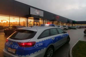 radiowóz policyjny jadący przed galerią handlową w związku z nowymi obostrzeniami związanymi z pandemią