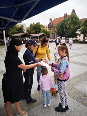 policjantka wręcza dzieciom odblaski