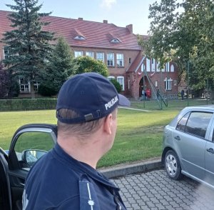 policjant obserwuje teren przy szkole