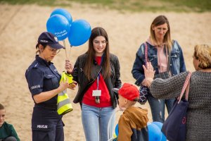 policjantka wręcza dziecku kamizelkę odblaskową