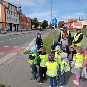 policjanci i dzieci stoją przy przejściu dla pieszych