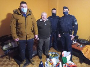 policjanci i starszy mężczyzna pozują do zdjęć