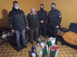 policjanci i starszy mężczyzna pozują do zdjęcia