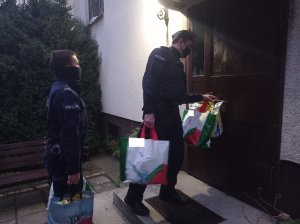 policjanci wchodzą do budynku z zakupami