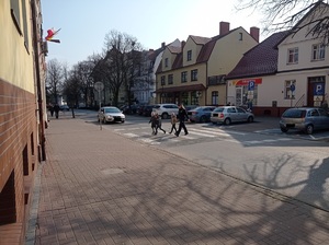 dzieci przechodzą przez jezdnię z policjantką