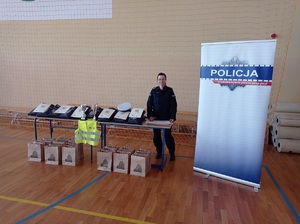 policjantka stoi przy stole z nagrodami dla uczestników turnieju