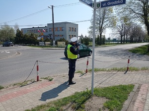 policjant ruchu drogowego mierzy prędkość jadących pojazdów ręcznym miernikiem prędkości