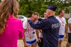 policjant wiesza na szyi zawodnika medal