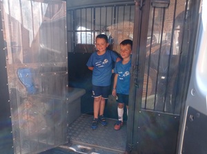 chłopcy stoją w policyjnym furgonie