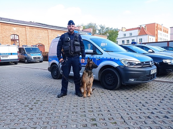 policjant przewodnik psa służbowego pozuje do zdjęcia