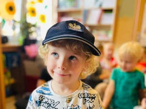dziecko pozuje do zdjęcia w policyjnej czapce
