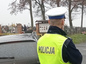 policjant ruchu drogowego obserwuje teren przy cmentarzu