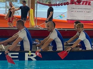 zawodnicy siedzą w smoczej łodzi