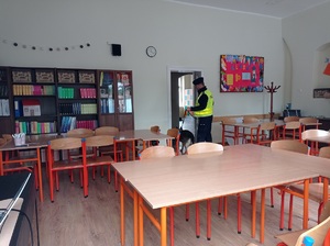 policjant sprawdza pomieszczenie w budynku szkoły