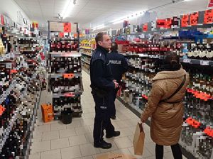 policjanci kontrolują punkt sprzedaży alkoholu