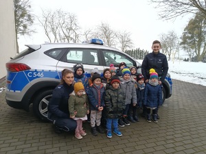 dzieci pozują do zdjęcia z policjantkami na tle radiowozu policyjnego