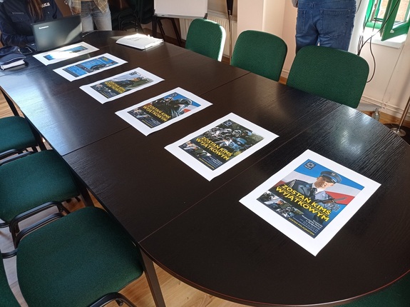 plakaty i broszury promujące pracę w Policji leżą na blacie stołu