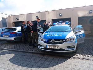 uczniowie oglądają policyjny radiowóz