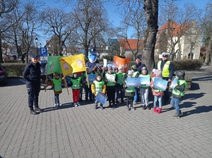 dzieci pozują do zdjęcia z plakatami