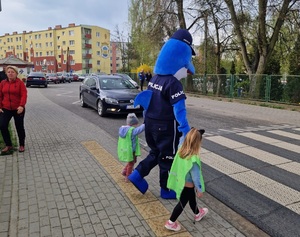 Polfin przechodzi przez jezdnię z dwójką dzieci