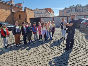 policjant pokazuje dzieciom wyposażenie do służby