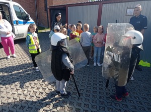 dzieci przymierzają sprzęt służbowy