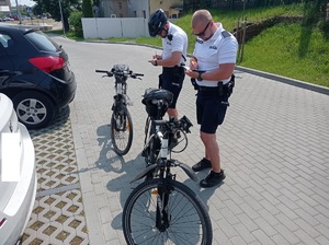 policyjni rowerzyści rozpisują notatniki służbowe