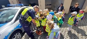 dzieci gromadzą się wokół policjanta