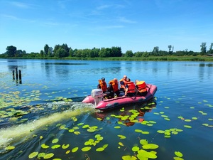 policjanci i strażacy odpływają pontonem od brzegu