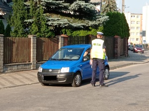 policjant stoi przy kontrolowanym pojeździe