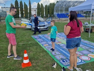 dorośli z dzieckiem grają w grę plenerową