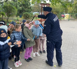 policjant rozdaje dzieciom odblaski