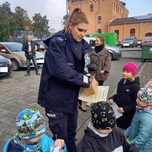 policjantka wręcza dzieciom odblaski