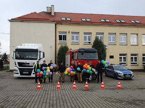 policjanci i strażacy pozują do zdjęcia