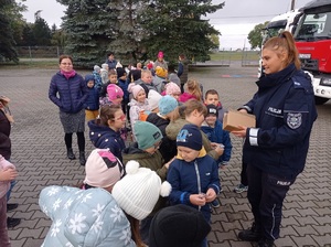 policjantka rozdaje dzieciom odblaski