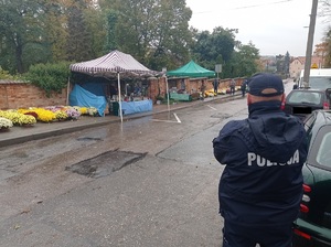 policjant obserwuje teren przy cmentarzu