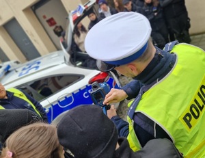 policjant pokazuje uczniom sprzęt do pomiaru prędkości pojazdów